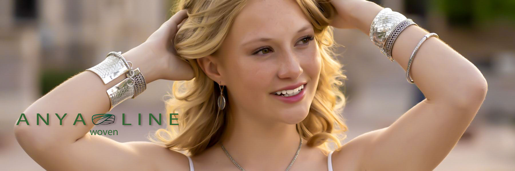 Woman wearing various woven sterling silver jewelry items.