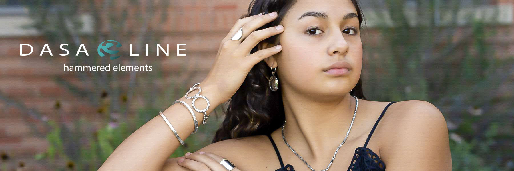 Woman wearing various hammered sterling silver jewelry items.