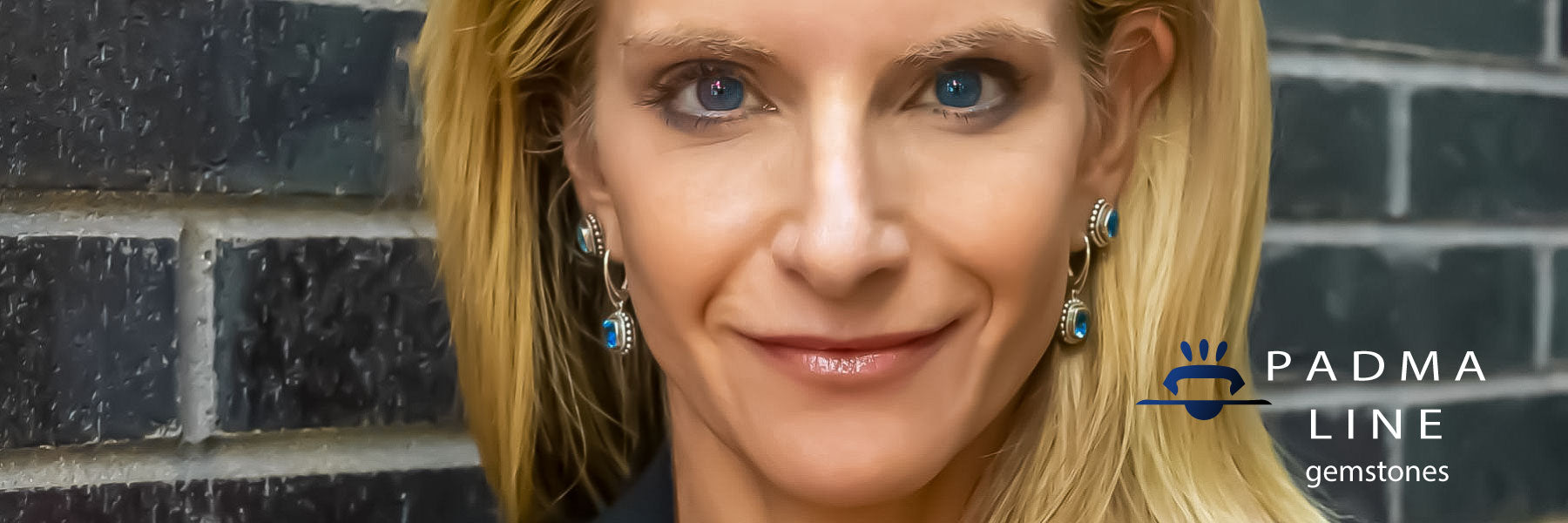 Woman wearing silver jewelry with blue topaz gemstones.