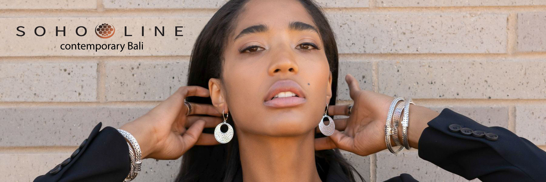 Woman wearing various dotted sterling silver jewelry items.