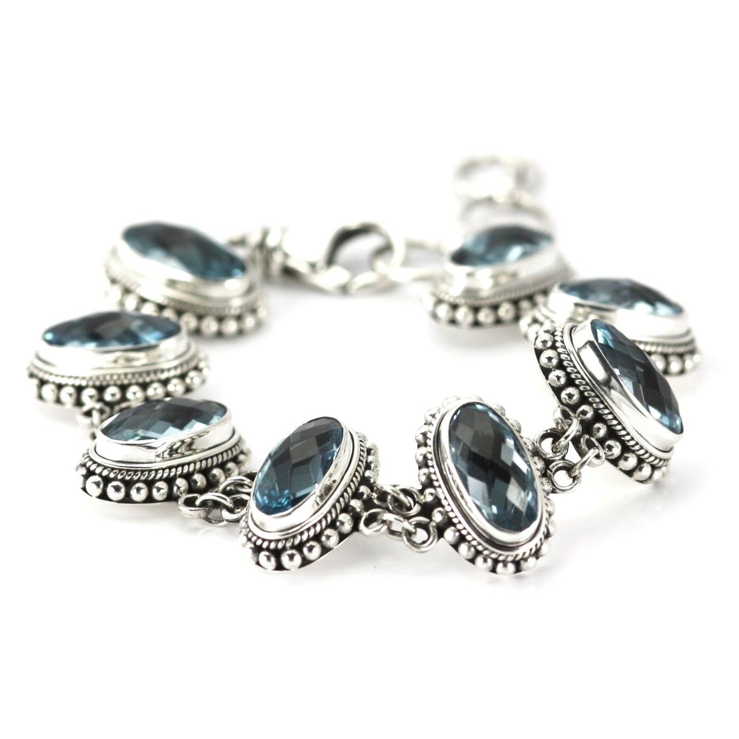 Silver bracelet with eight large sky blue topaz gemstones set perpendicular.