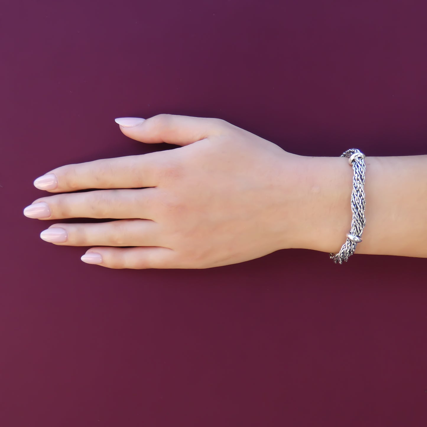 Woman wearing a twisted wheat chain bracelet.