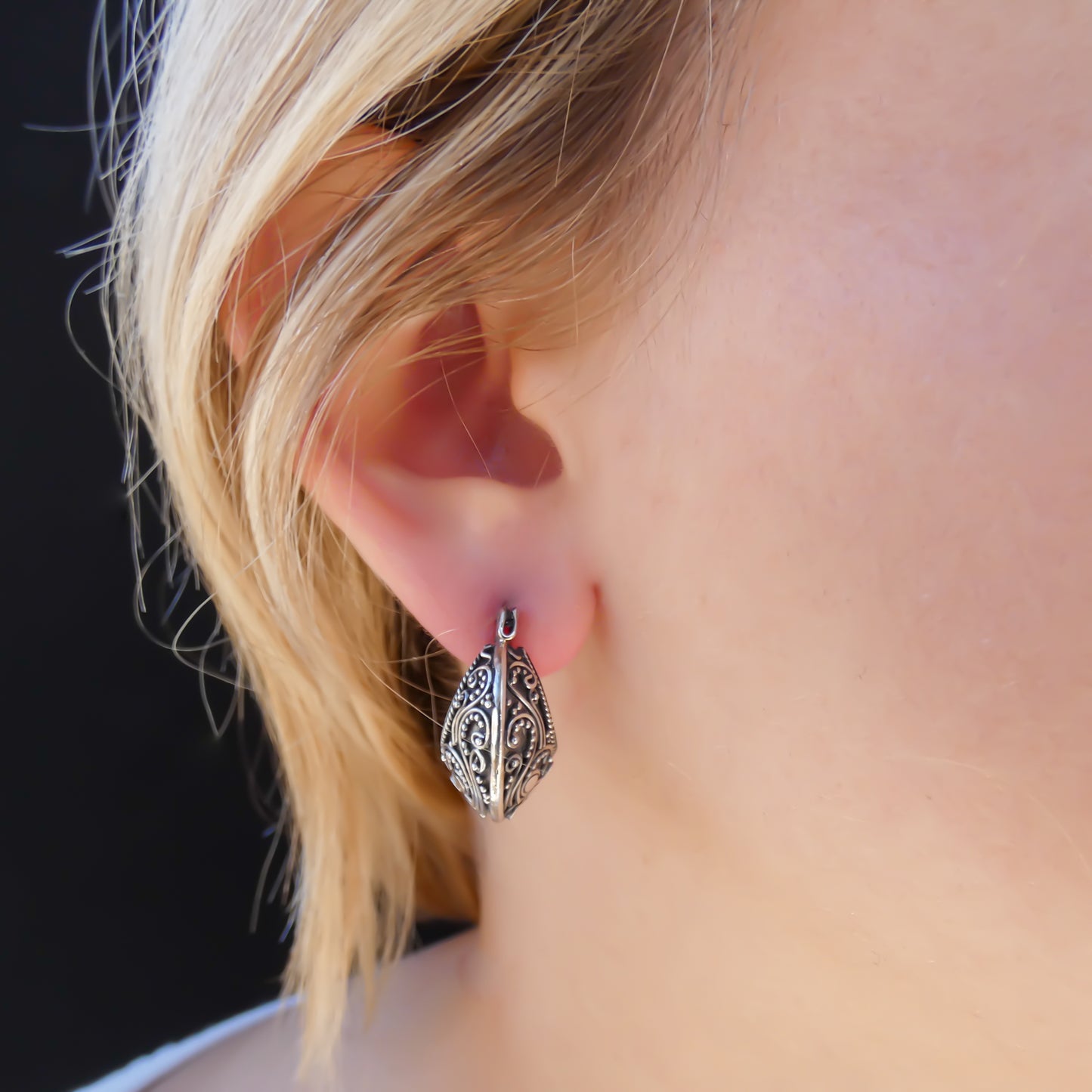 Sterling silver huggie filigree motif earrings.