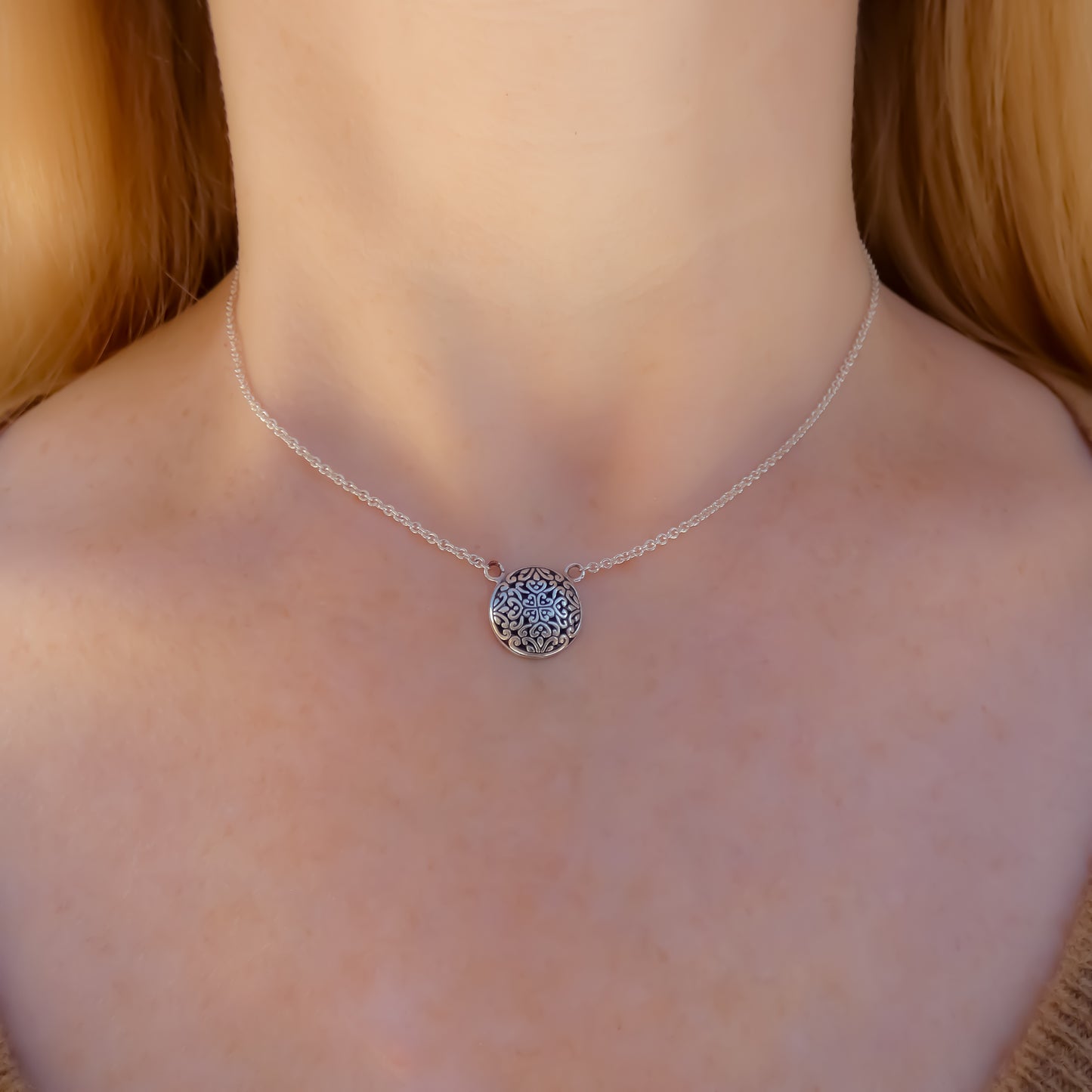 Sterling silver necklace with lightweight chain and round filigree design station.