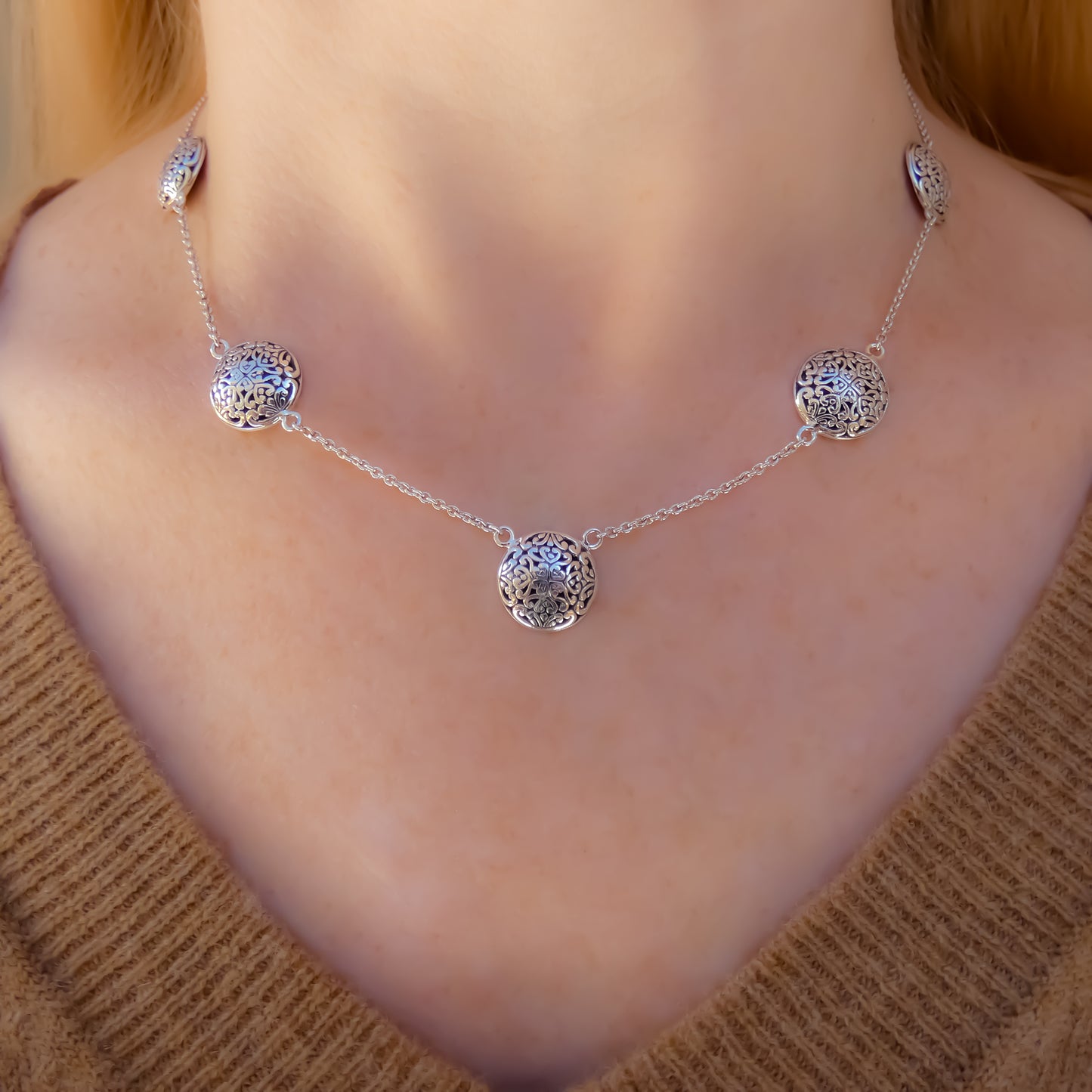 Sterling silver necklace with lightweight chain and round filigree design stations.