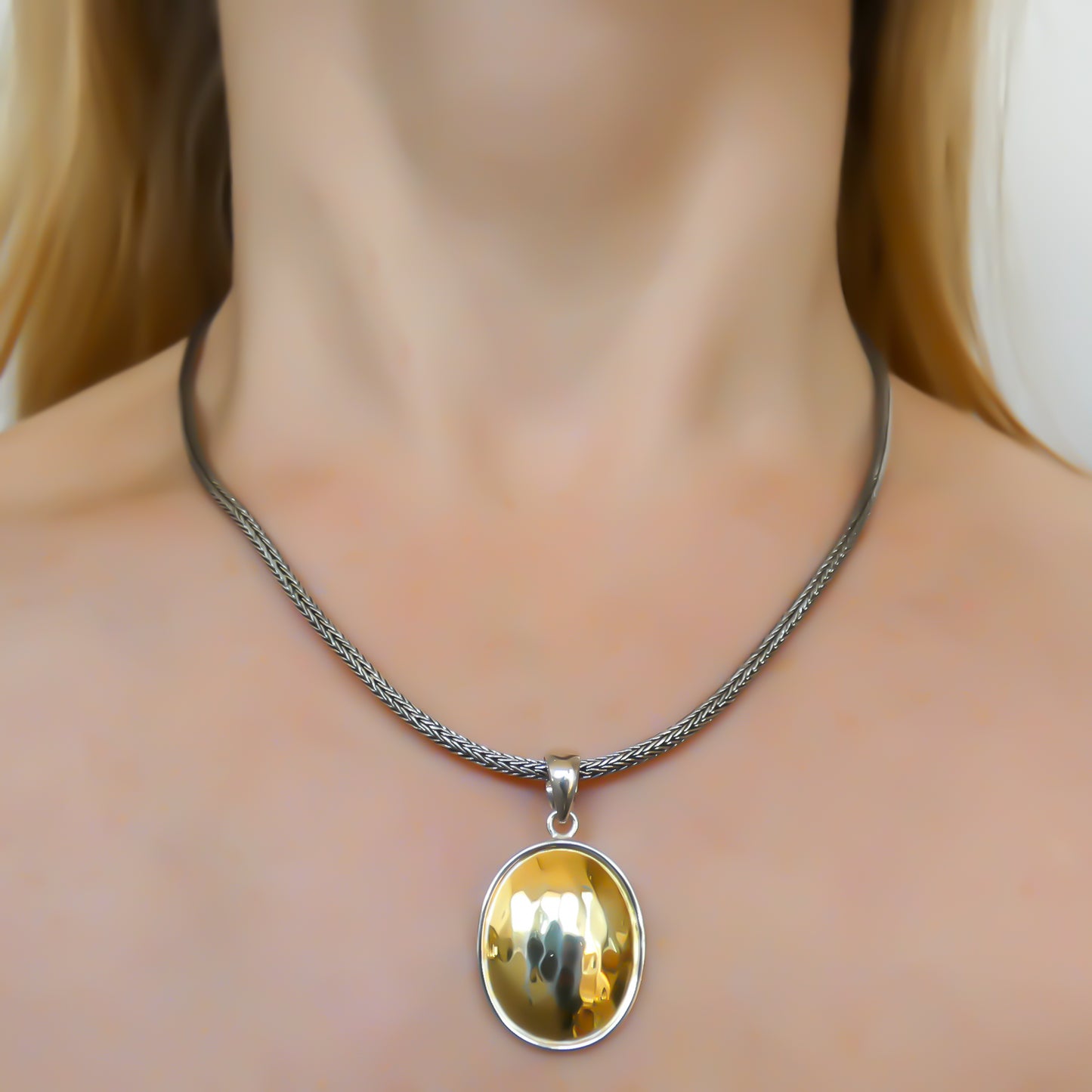 Sterling silver and gold oval pendant.