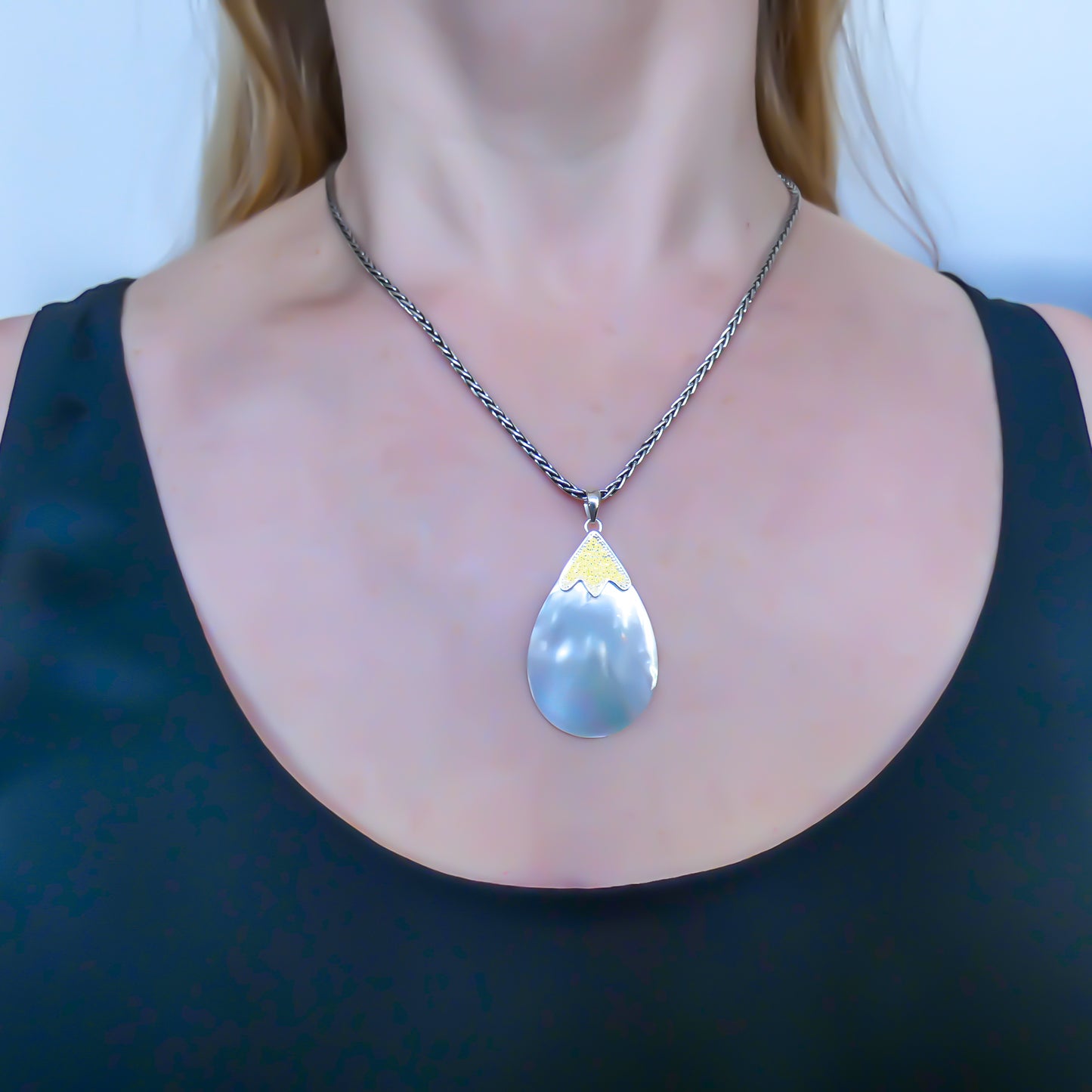 Sterling silver and gold pendant with mother of pearl.