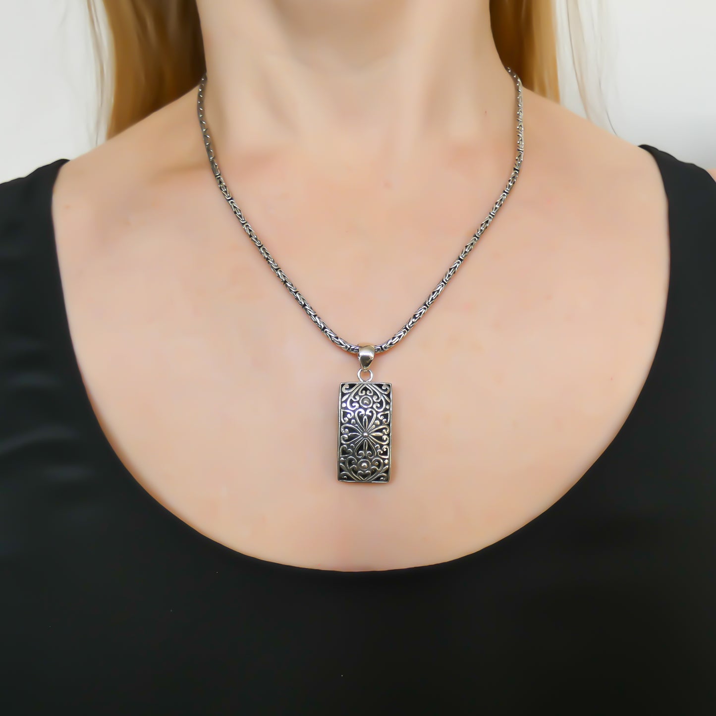 Sterling silver rectangular floral pendant.