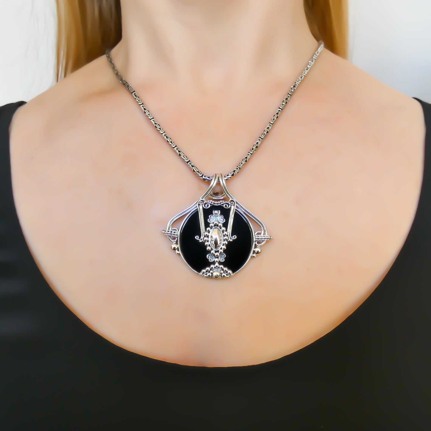 Sterling silver and black onyx disc pendant.