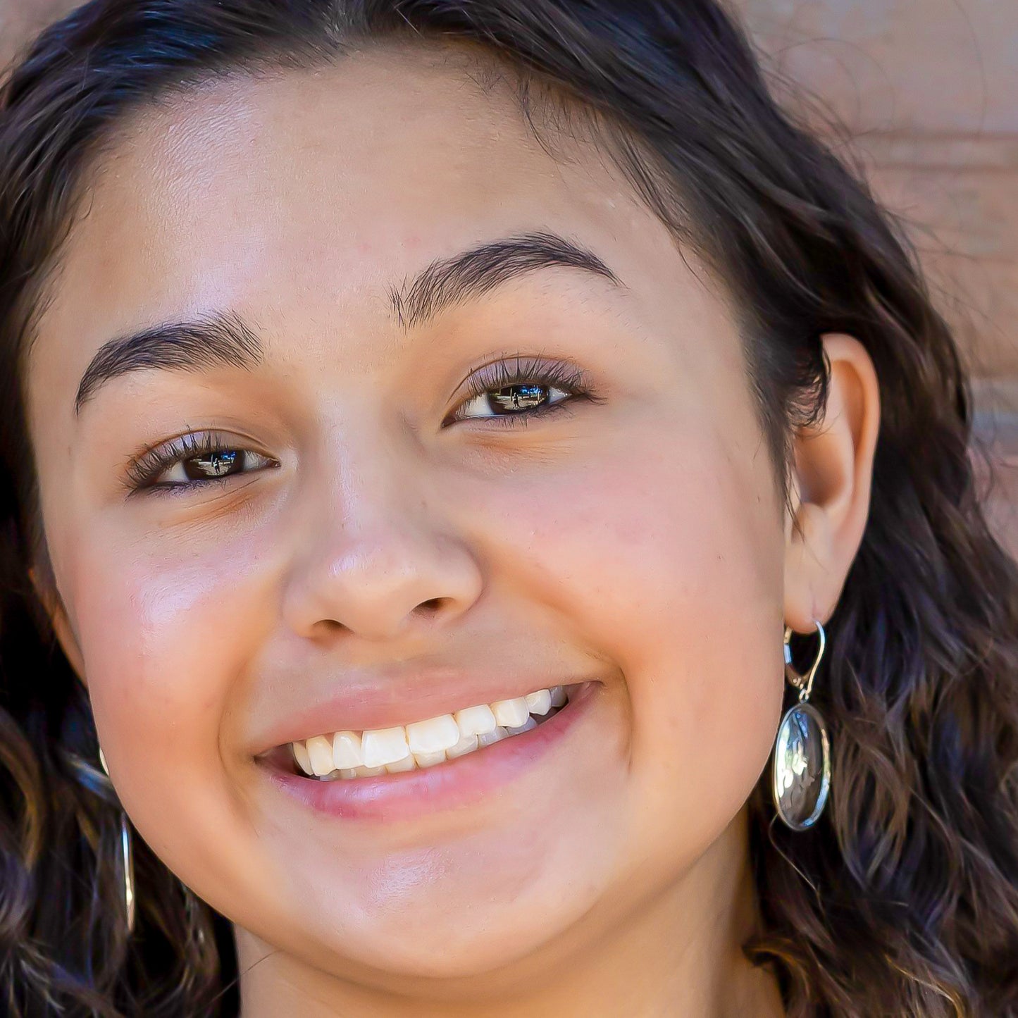 Woman wearing silver oval hammered earrings.