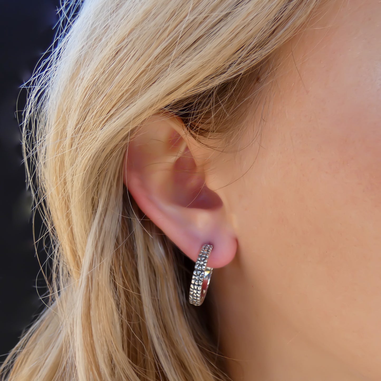 Sterling silver textured hoop earrings.
