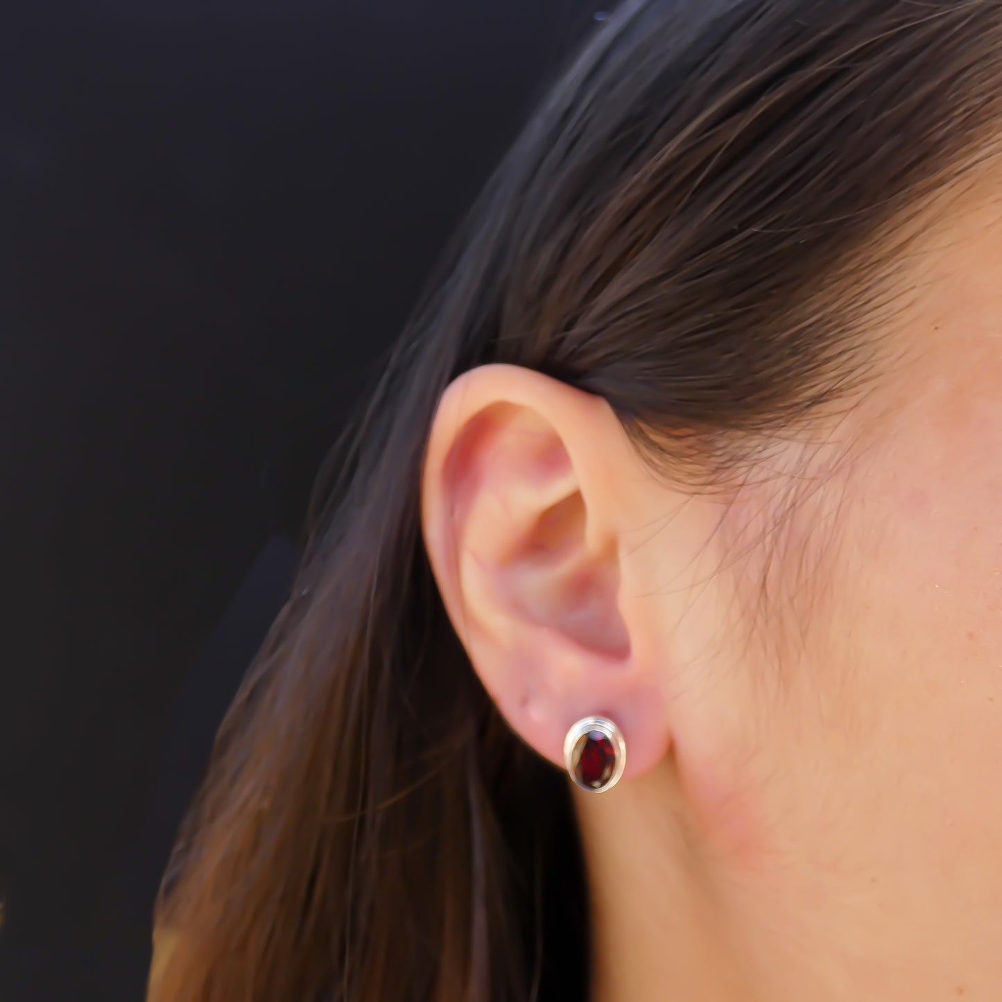 High polish plain setting sterling silver oval post earrings with garnet.