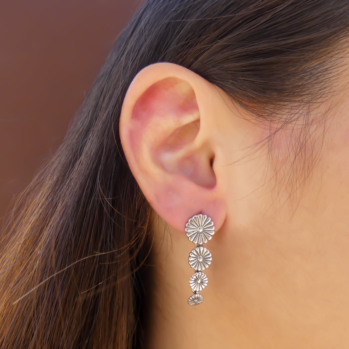 Sterling silver four flower dangle earring.