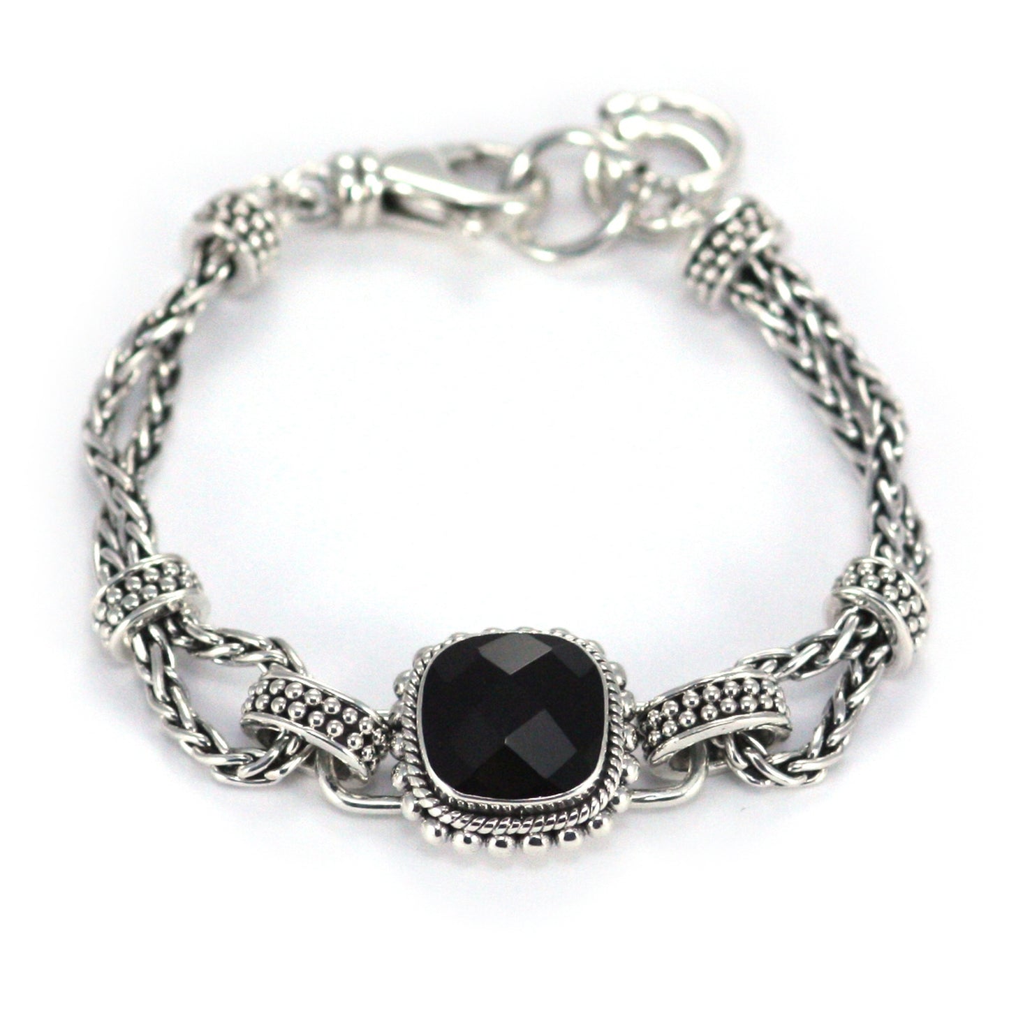 Silver bracelet made of wheat chain elements and a centered station with a single faceted black onyx stone.