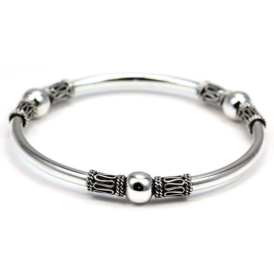 Silver bangle bracelet with three stations that have polished mirror beads and rope trim designs.