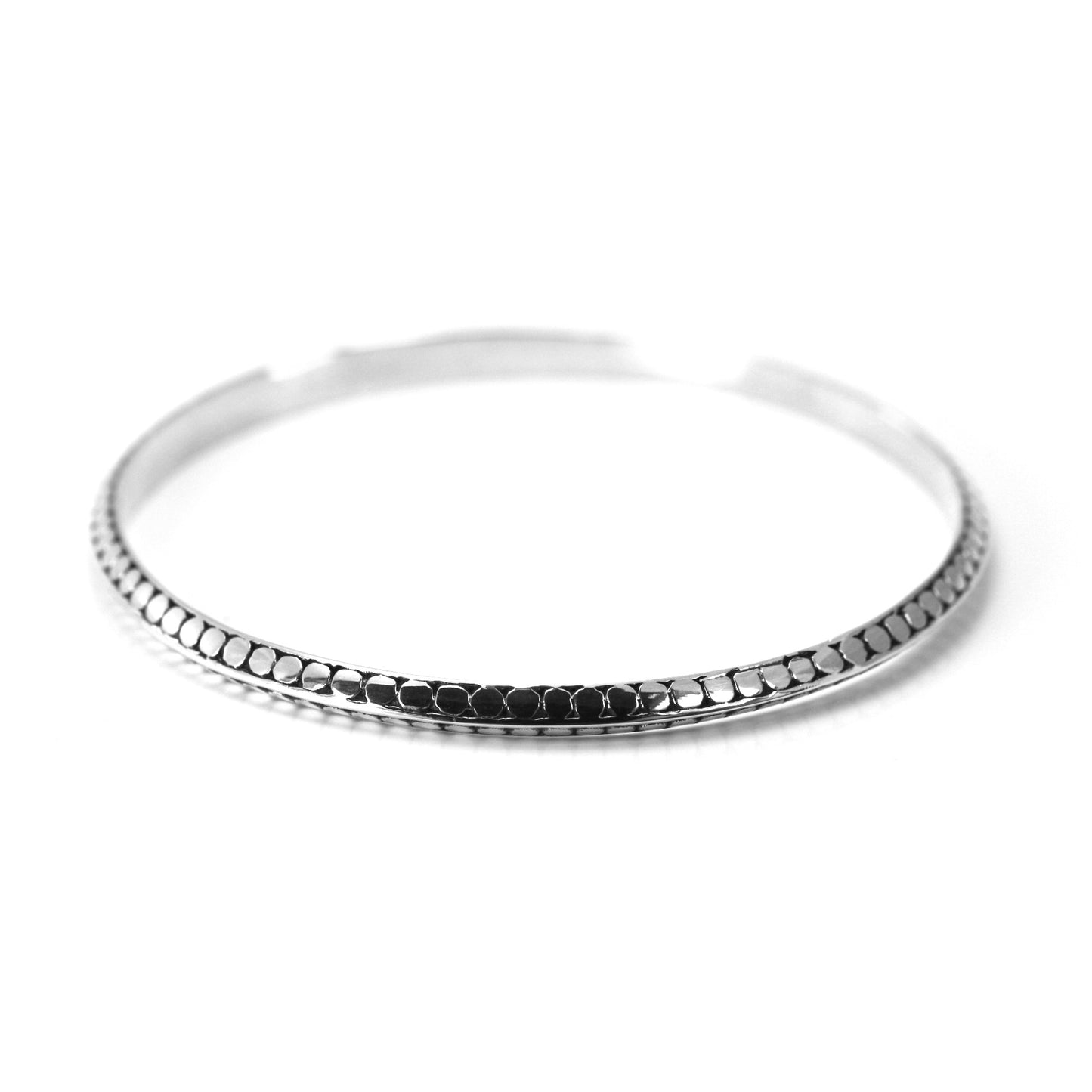 Bangle bracelet with flat dots and a triangular profile.