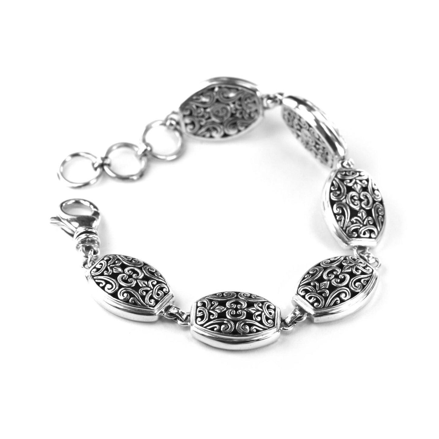Silver bracelet with oval ornate links and a lobster clasp.