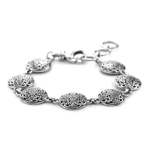 Silver bracelet with seven round filigree links.