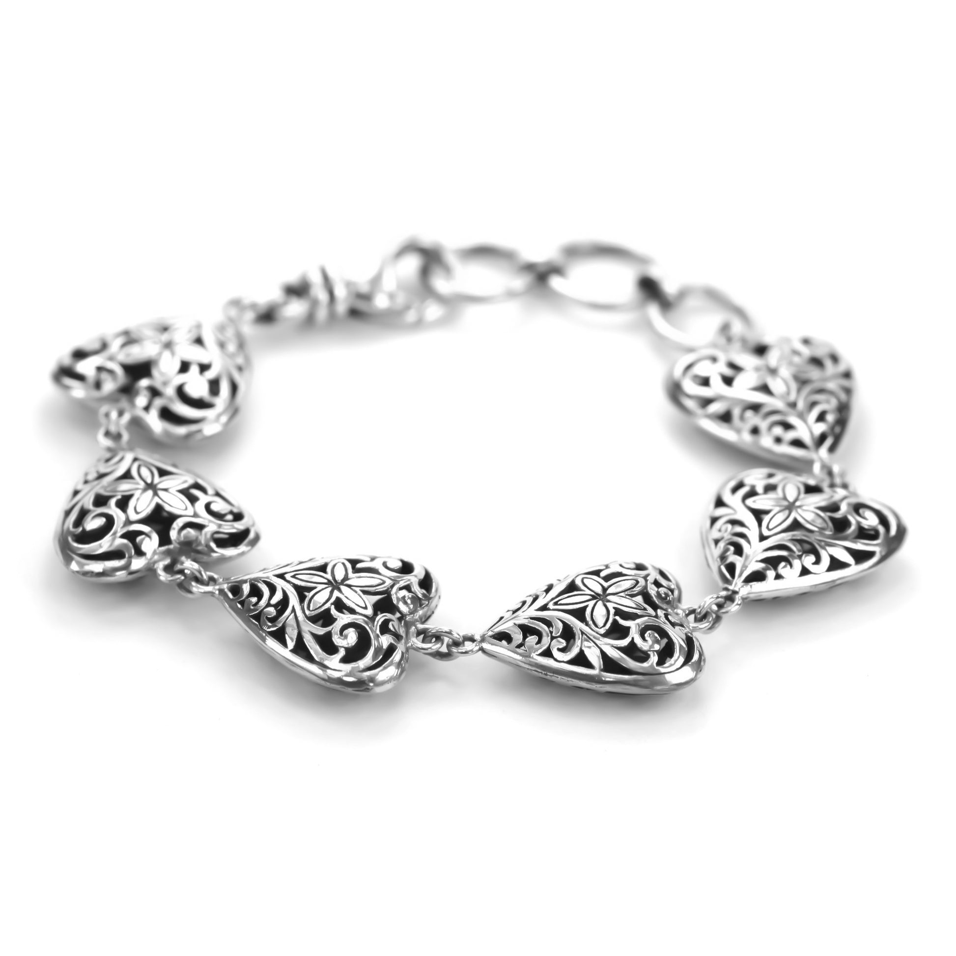 Silver bracelet with six ornate filigree heart stations.
