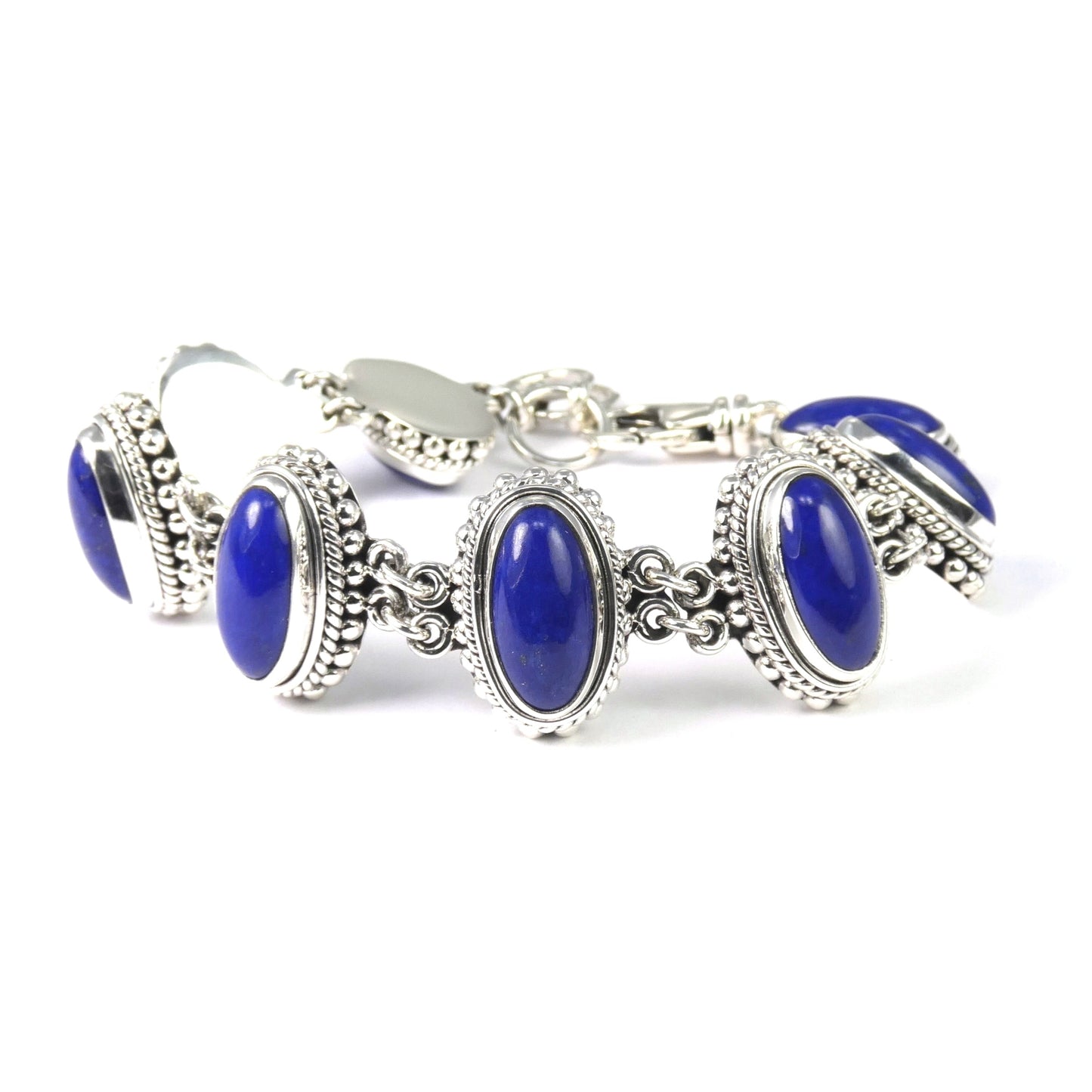 Silver link bracelet with eight blue cabochon lapis stones set in beaded links.