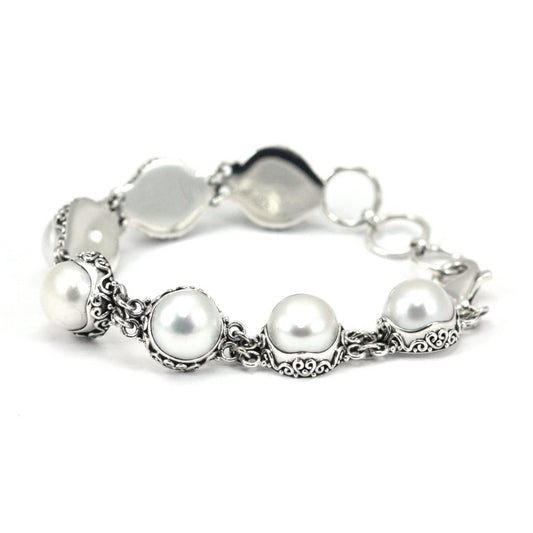 Silver bracelet with large pearl stations with filigree detail, and solid silver back plates.