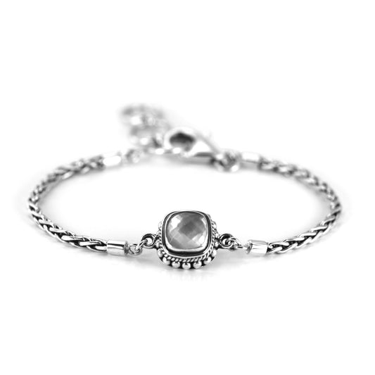 Silver bracelet with wheat chain arms and a centered station with a single mother of pearl doublet gemstone.