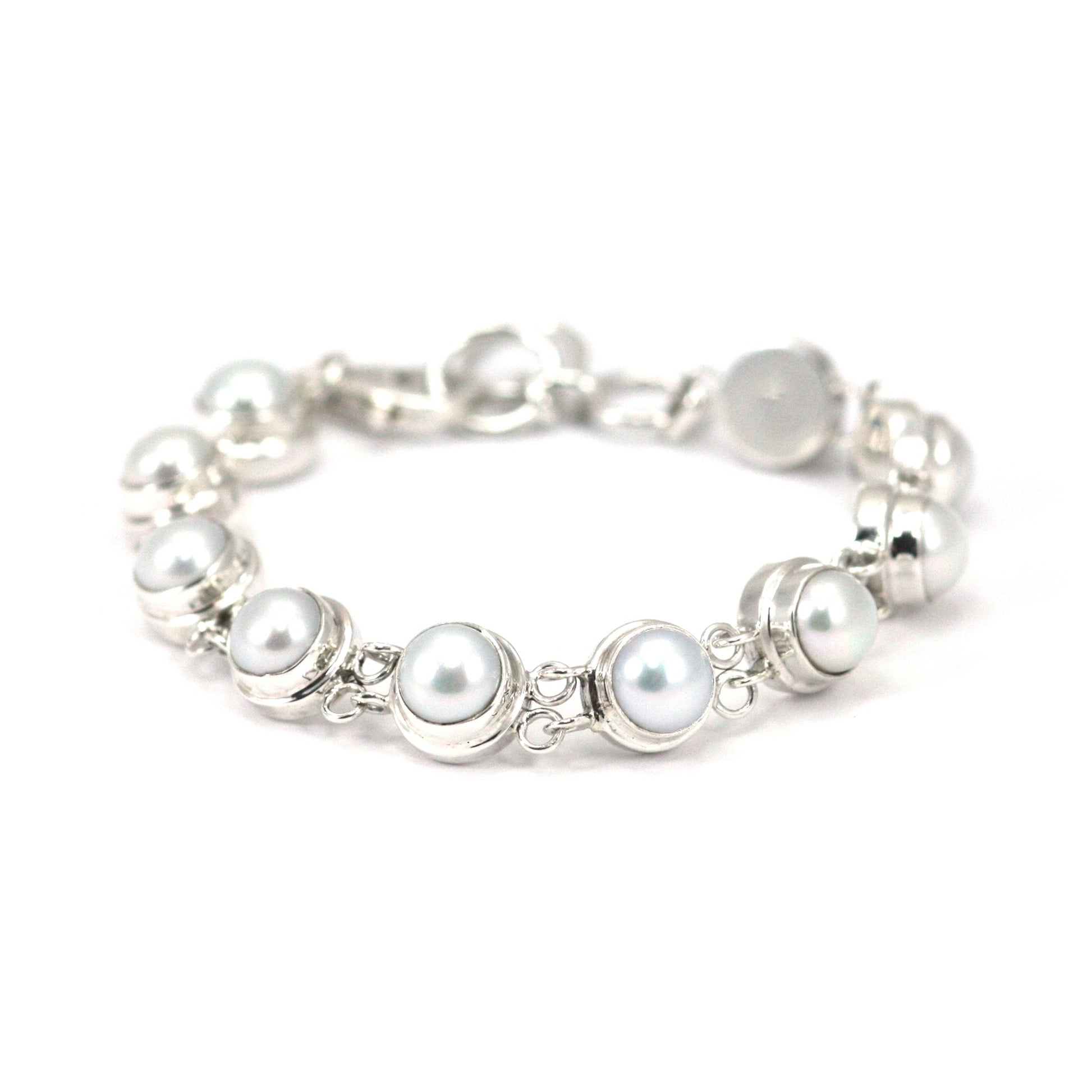 Silver bracelet with ten round links with white pearls.