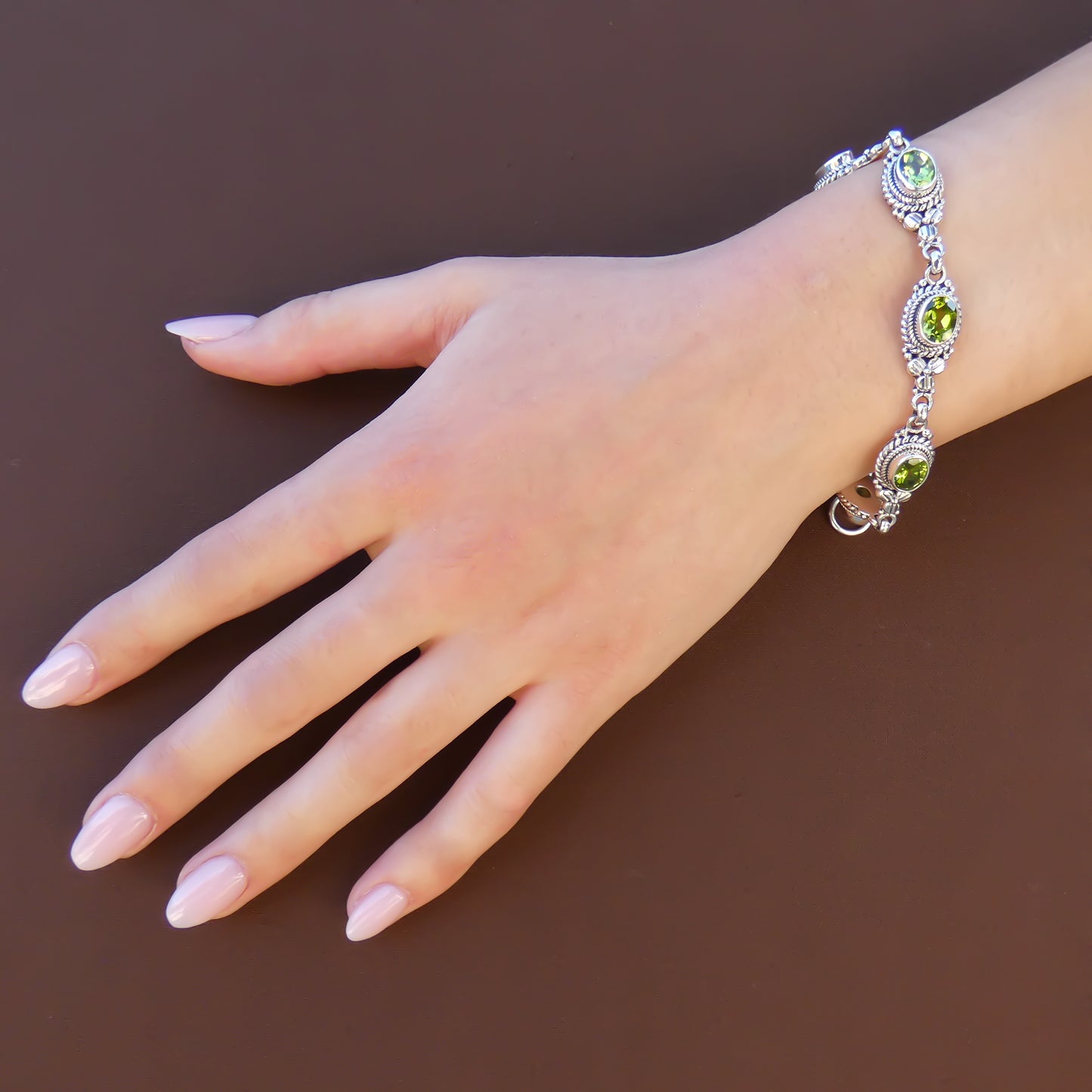 Woman wearing peridot silver link bracelet.