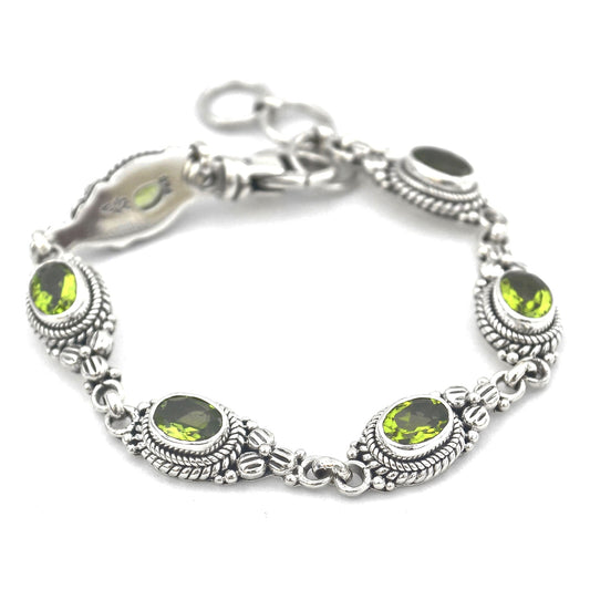 Silver bracelet with oval green peridot gemstones set in floral links.