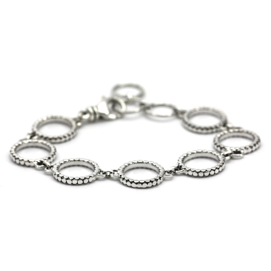 Bracelet made of seven ring links with flat silver dots going around each ring.