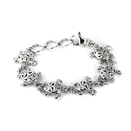 Silver link bracelet with six sea turtles connected together in line.