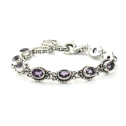 Silver link bracelet with nine light purple amethyst gemstones and beaded accents.