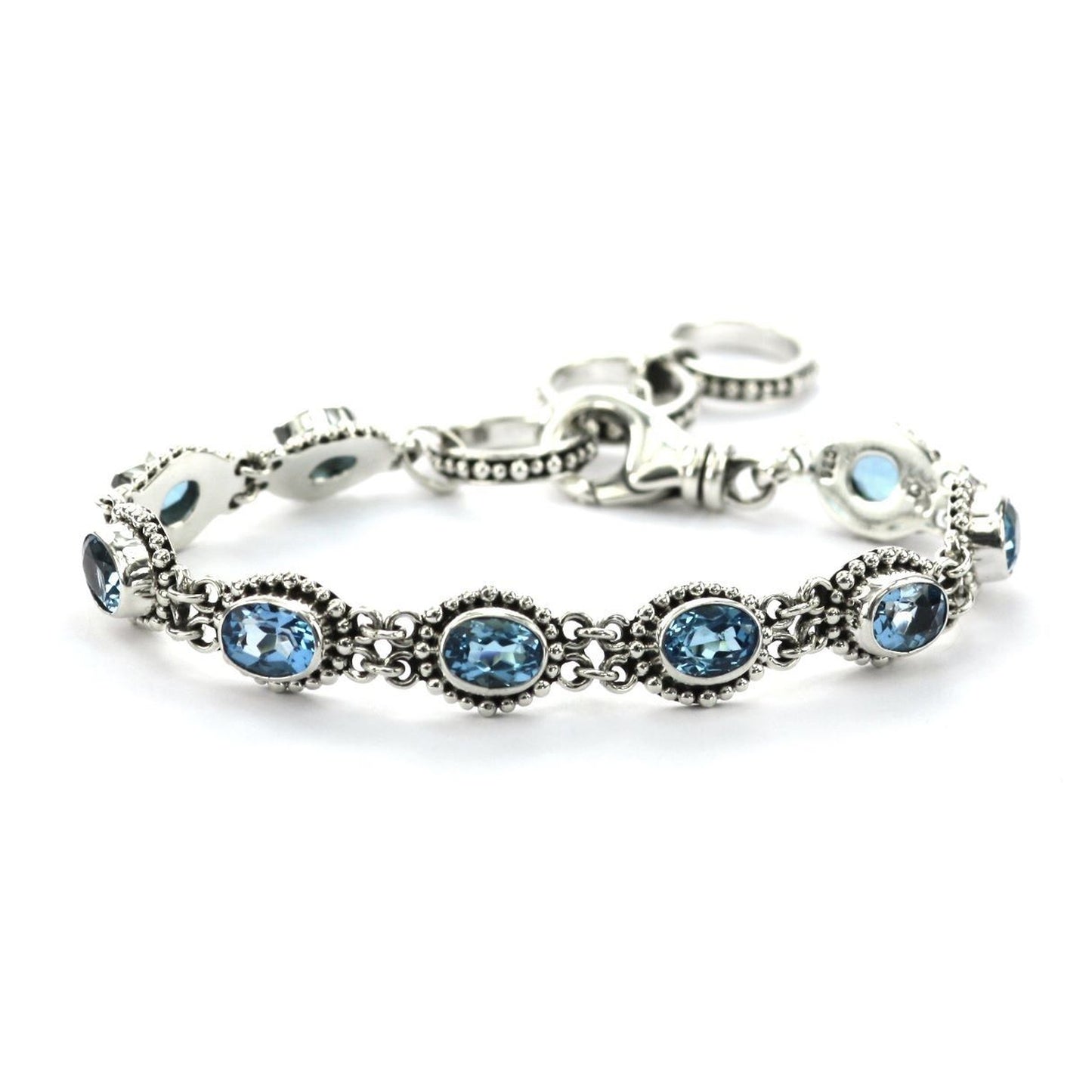 Silver bracelet with nine blue topaz gemstones set in beaded links.