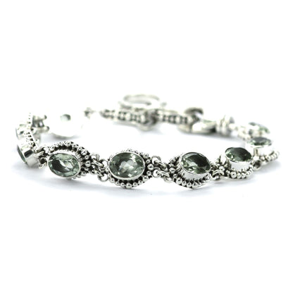 Silver link bracelet with nine green amethyst gemstones and beaded accents.