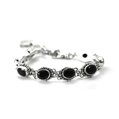 Silver bracelet with nine oval onyx gemstones set in beaded links.