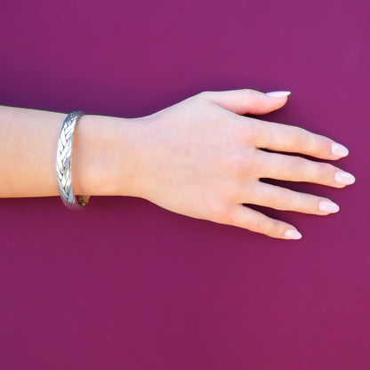 Woman wearing a wide woven silver cuff bracelet.