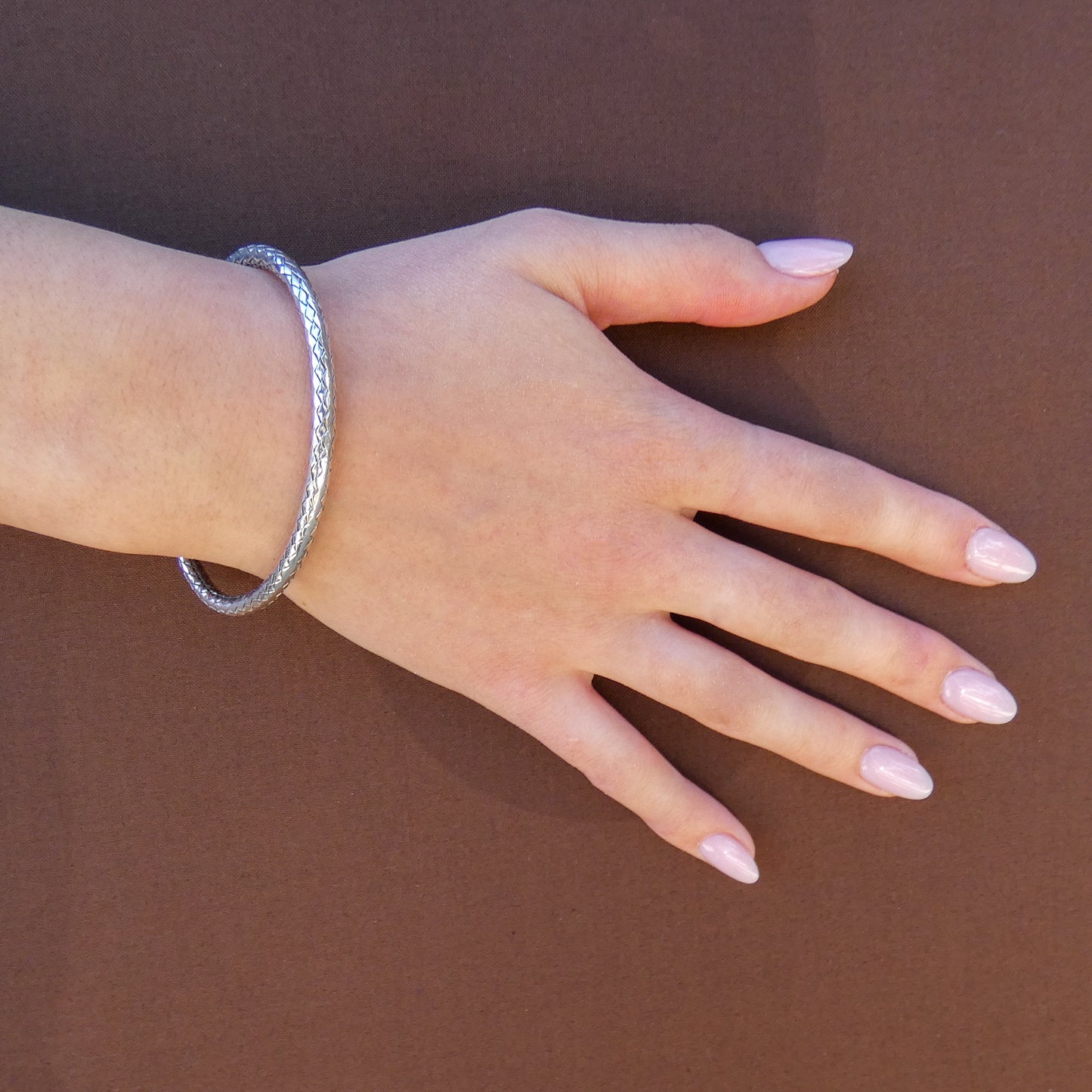 Woman wearing a woven single bangle bracelet.