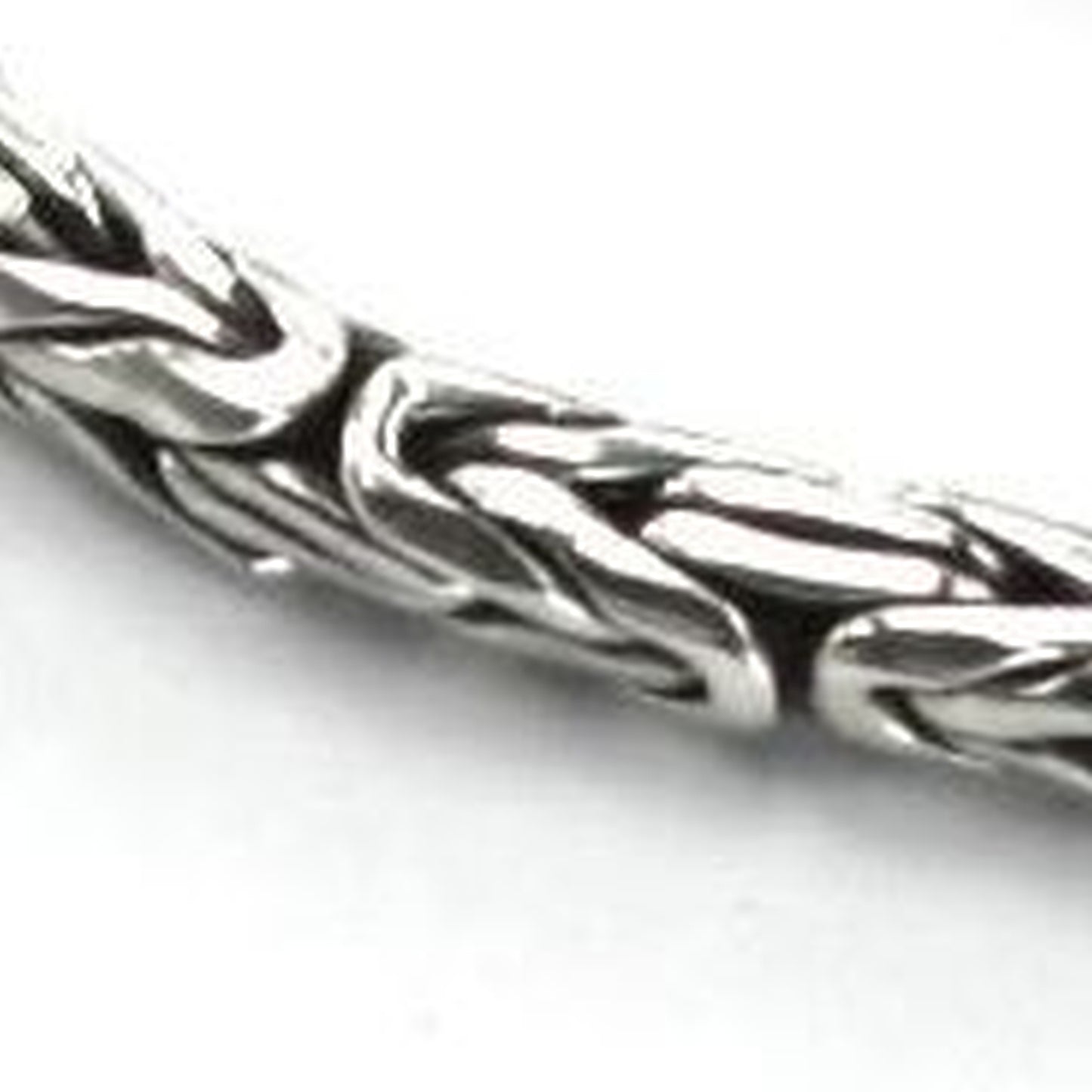 Close-up of a silver byzantine chain bracelet.