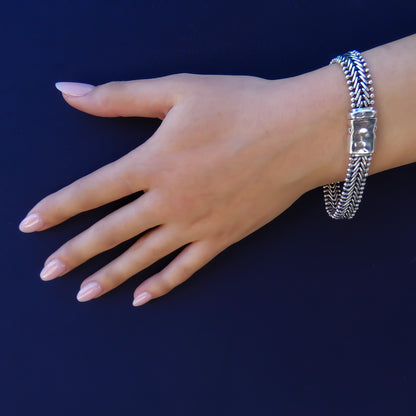 Woman wearing a flat herringbone bracelet with hammered clasp.