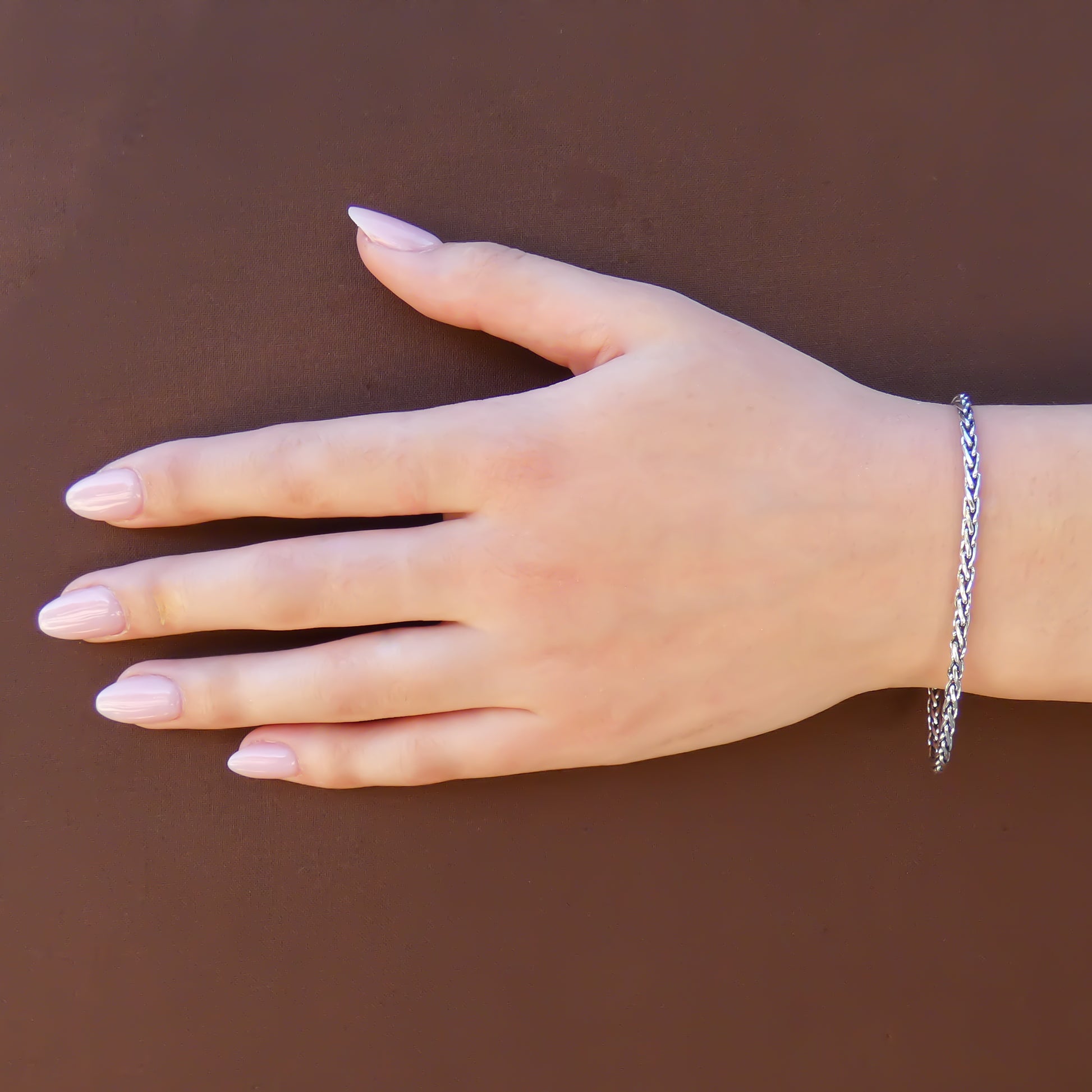 Woman wearing a wheat style thin chain bracelet.