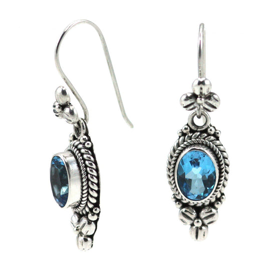 Silver wire drop earrings with oval blue topaz stones and floral design.