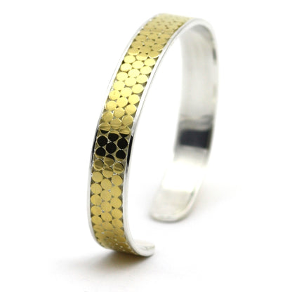 Silver and gold cuff bracelet with three rows of flat dots.