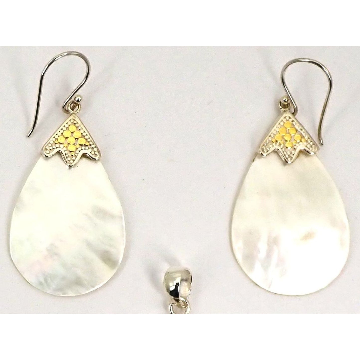 Silver and gold earrings with teardrop shell stones.