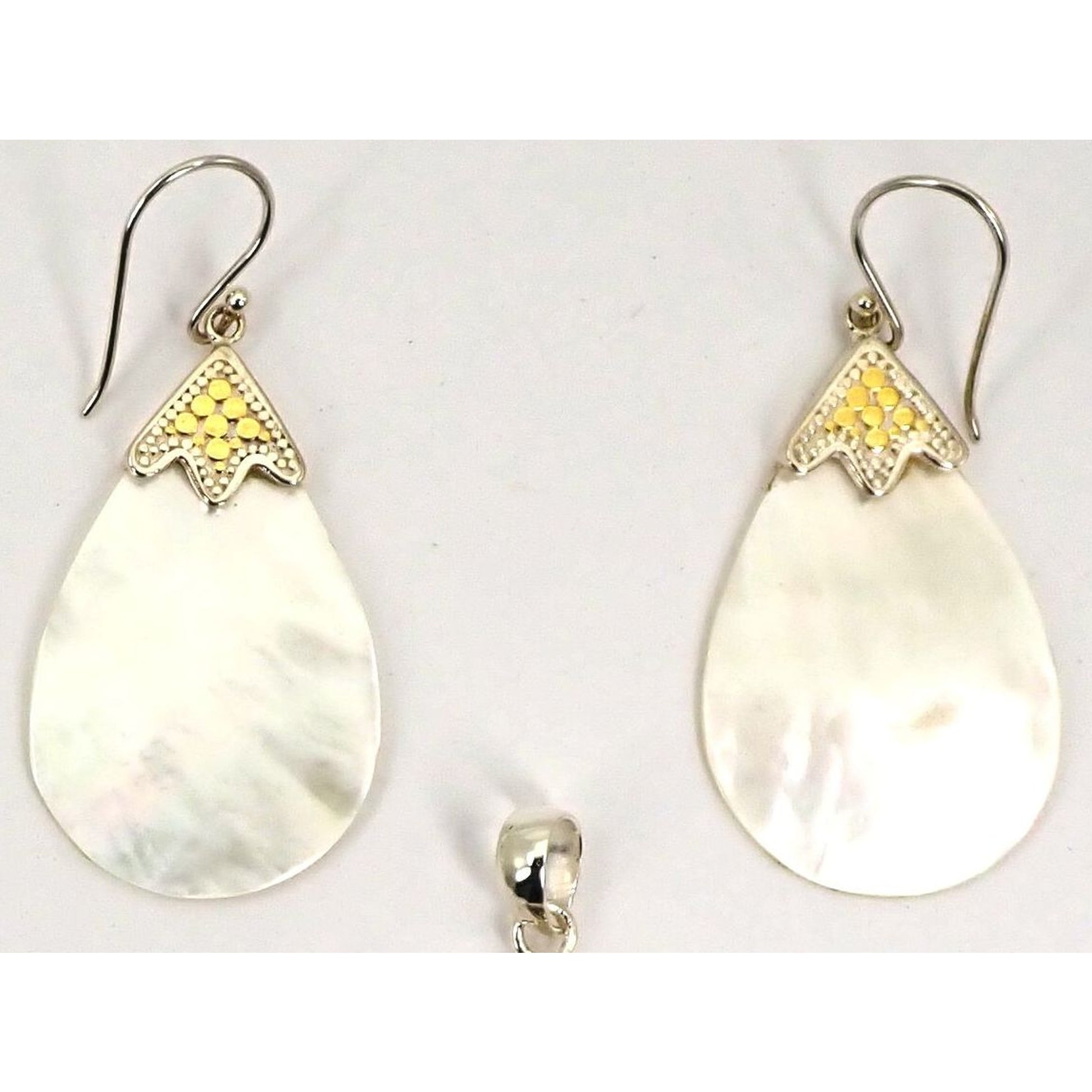 Silver and gold earrings with teardrop shell stones.