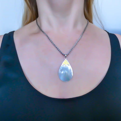Sterling silver and gold pendant with mother of pearl.