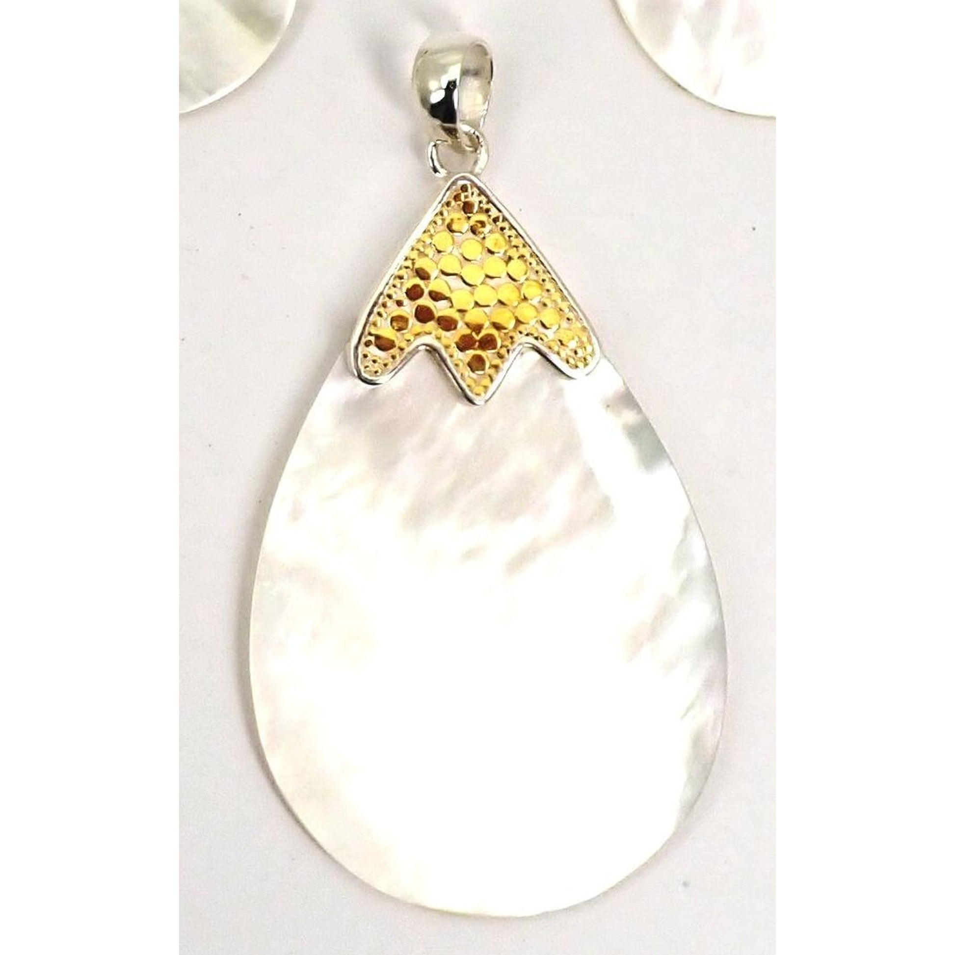 Sterling silver and gold pendant with mother of pearl.