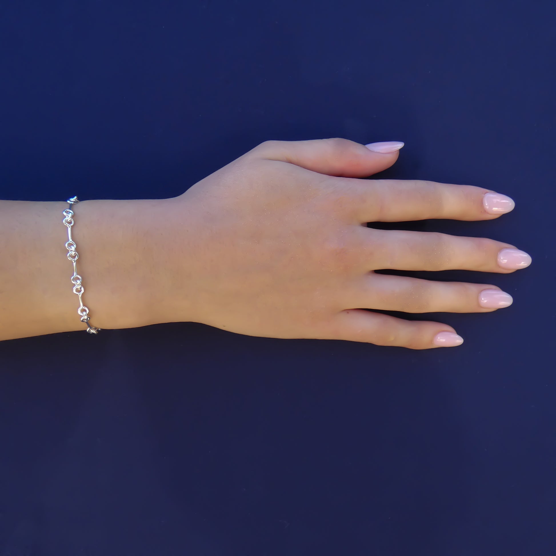 Woman wearing a lightweight silver link bracelet.