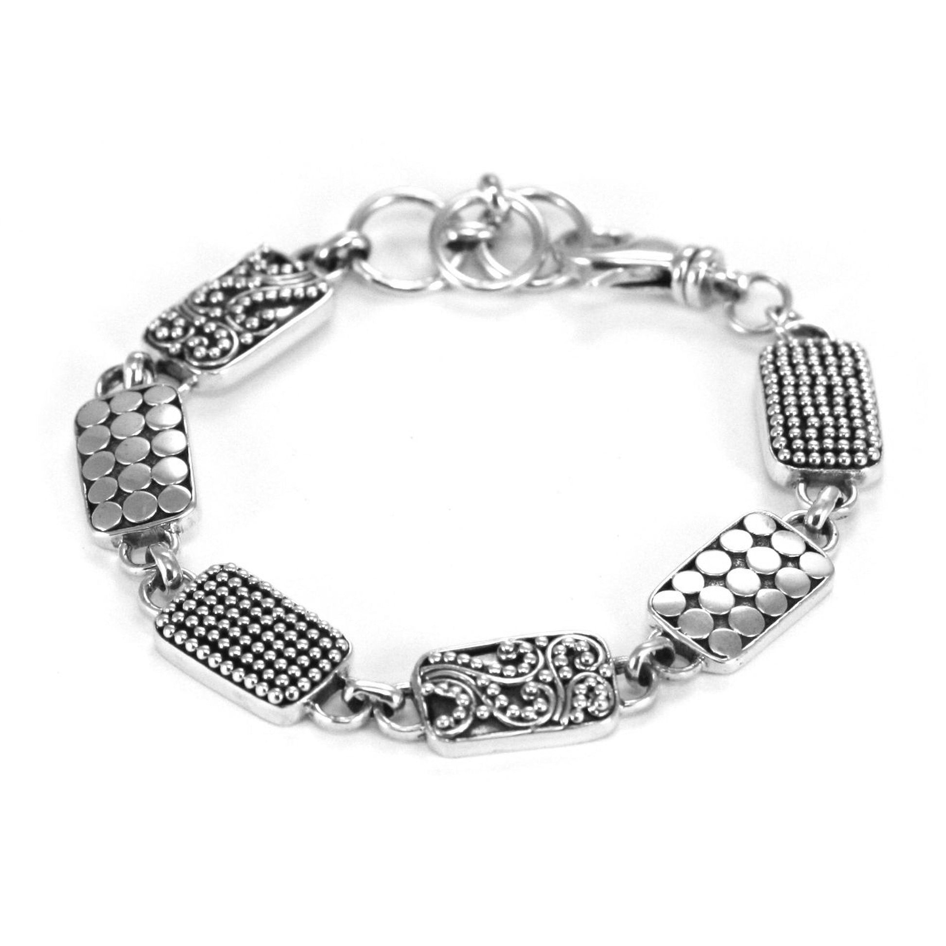 Silver bracelet made of six rectangular links with three different design styles. and a lobster clasp.