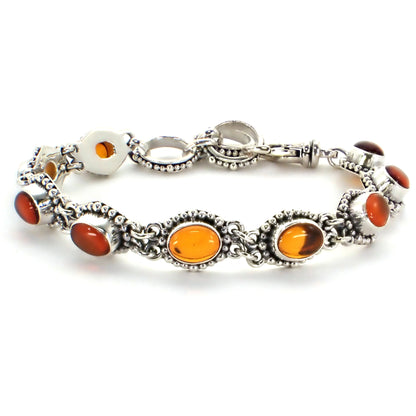 Silver link bracelet with nine oval amber gemstones and beaded borders on each link.