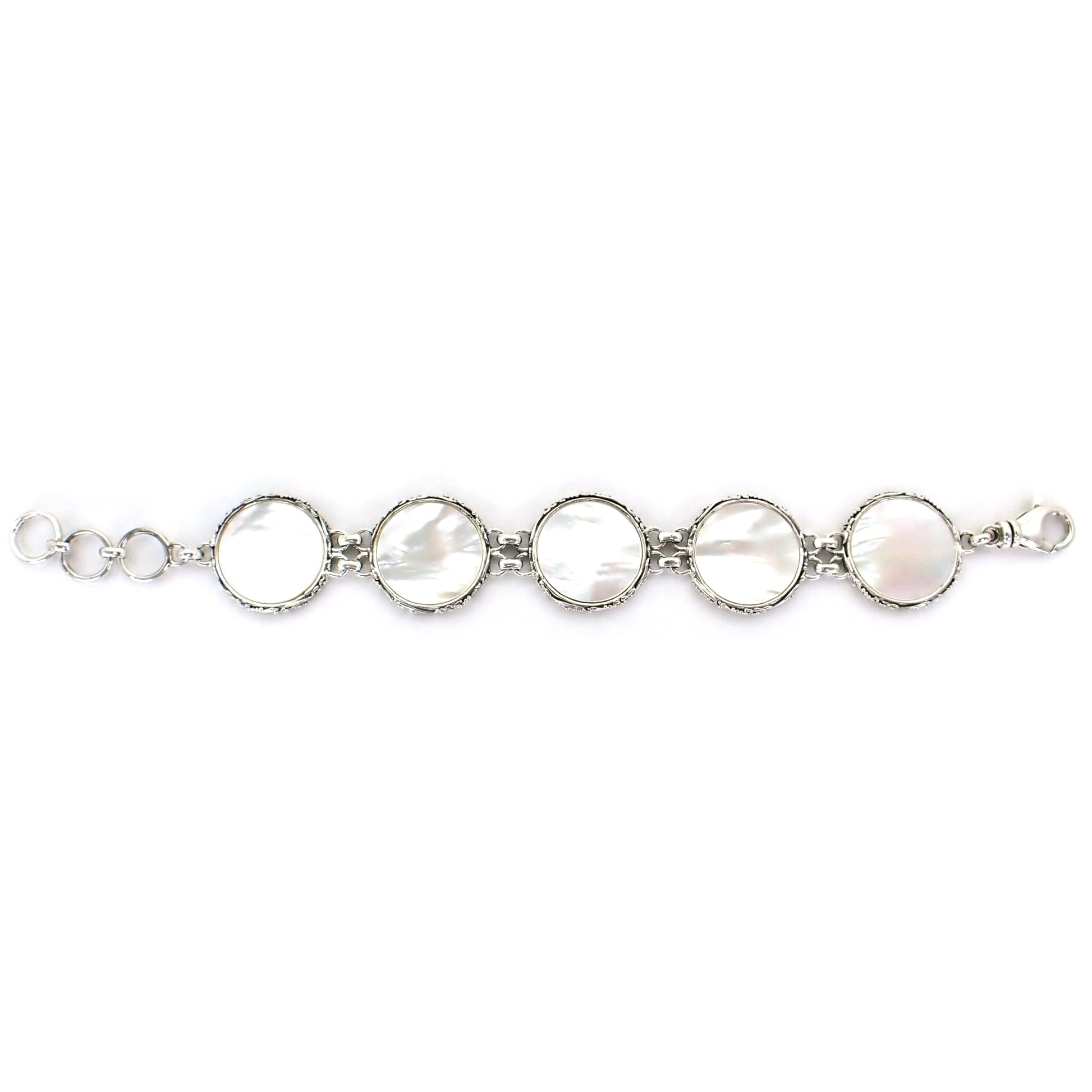 Bracelet laid out flat made of five round links, each with a mother of pearl disc and ornate silver border.